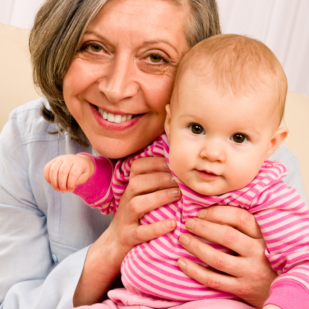 Grandmother hold little baby girl smiling
